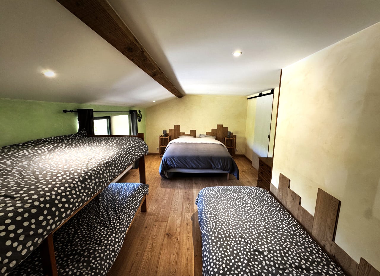 Chambre Côté Jardin aux chambres d’hôtes Chez Delphine à Doizieux, avec un lit double, un lit simple et un lit superposé.