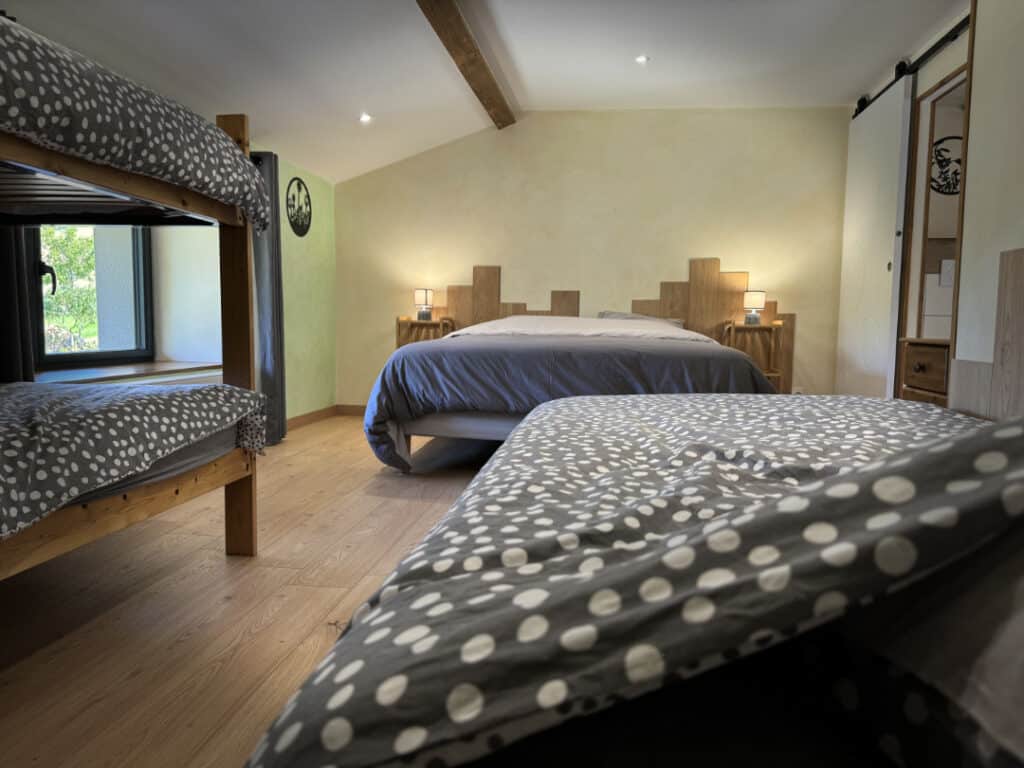 Chambre familiale Côté Jardin avec lit double, lit simple et lits superposés, dans un gîte à Doizieux.
