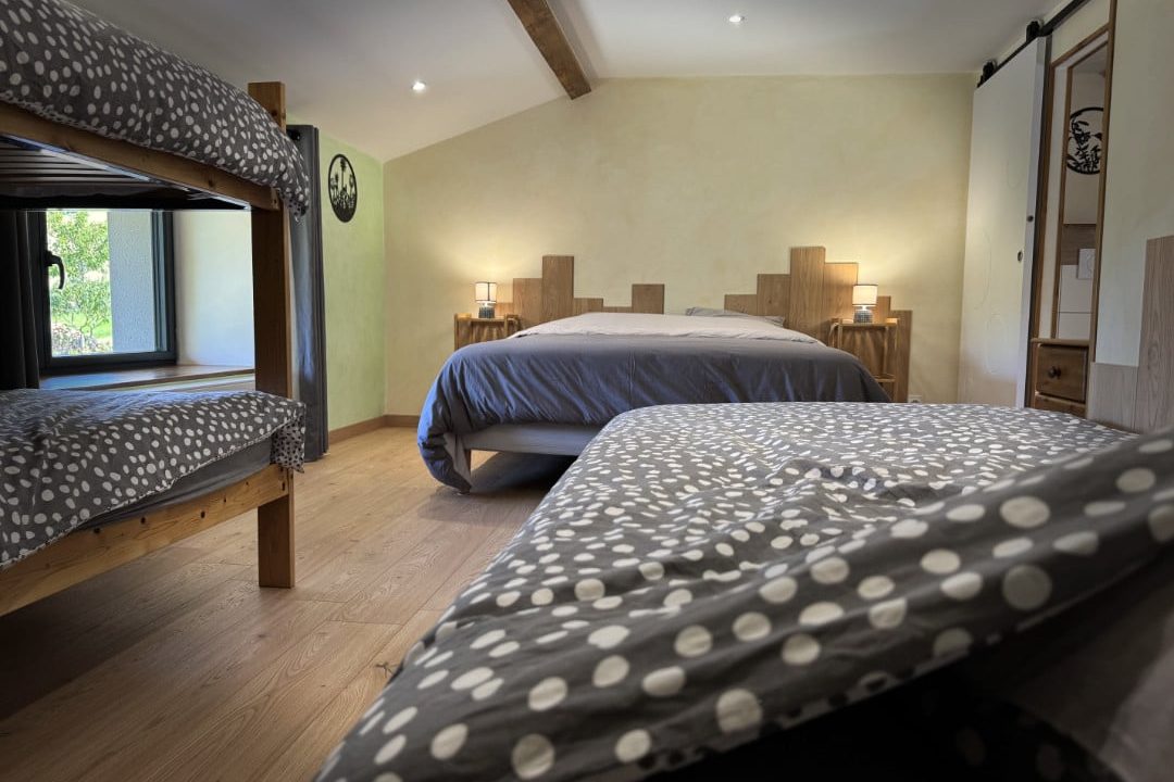 Chambre familiale Côté Jardin avec lit double, lit simple et lits superposés, dans un gîte à Doizieux.