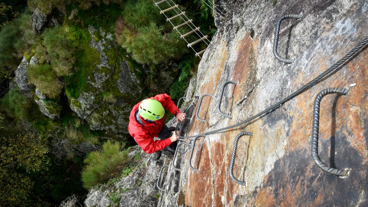 Grimpeur sur une via ferrata du massif du Pilat, échelons et câble de sécurité au-dessus des gorges, à quelques minutes de Doizieux.
